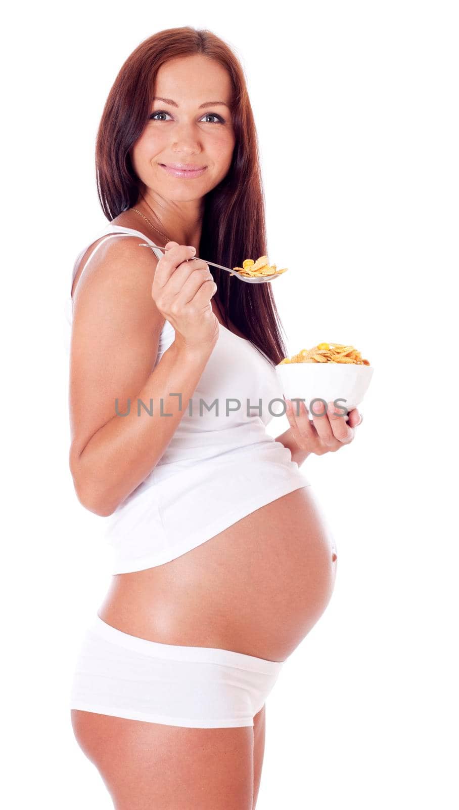 Pregnant woman eating corn flakes, isolated on white.