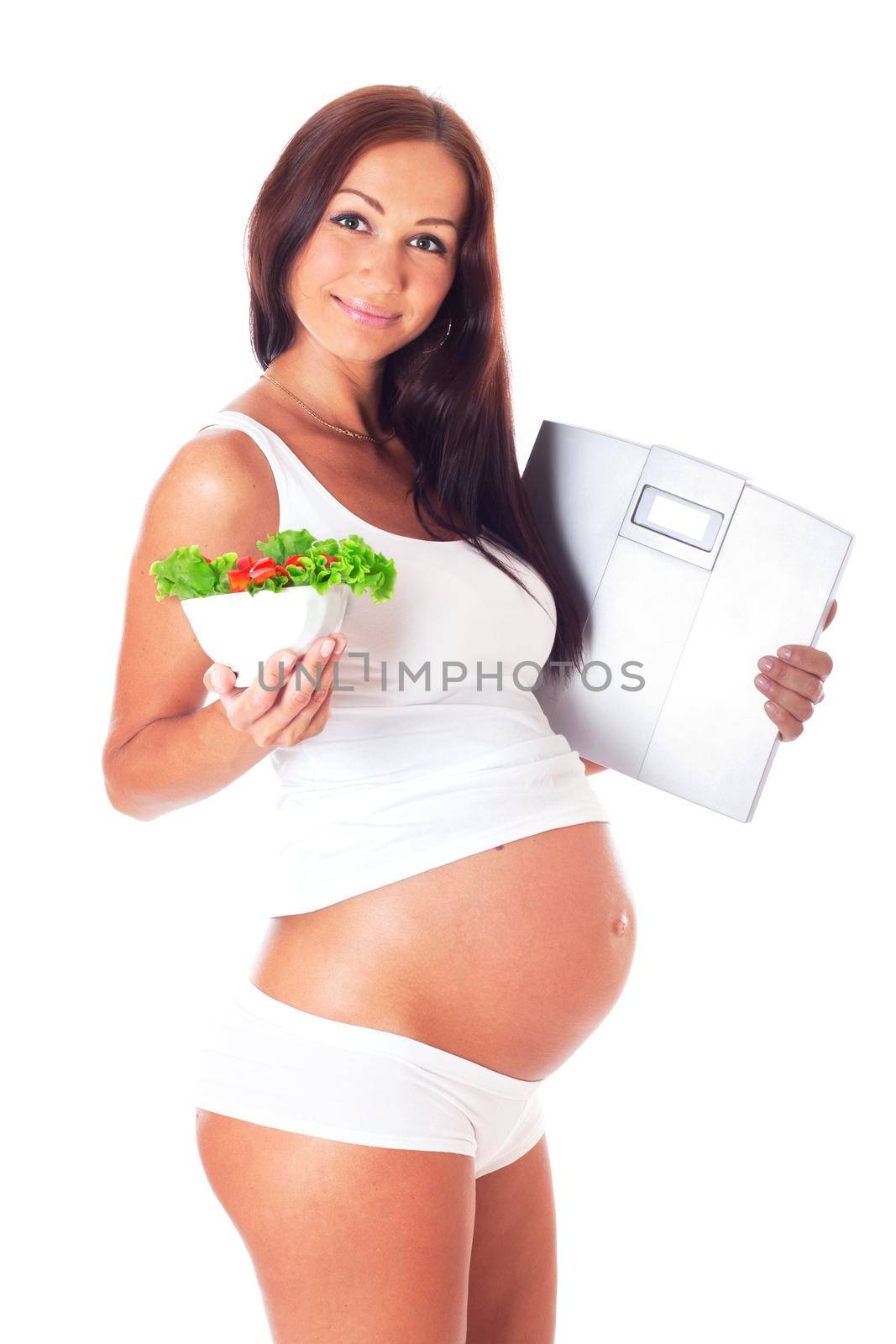 Pregnant woman holding scales in one hand to another salad, isolated on white.