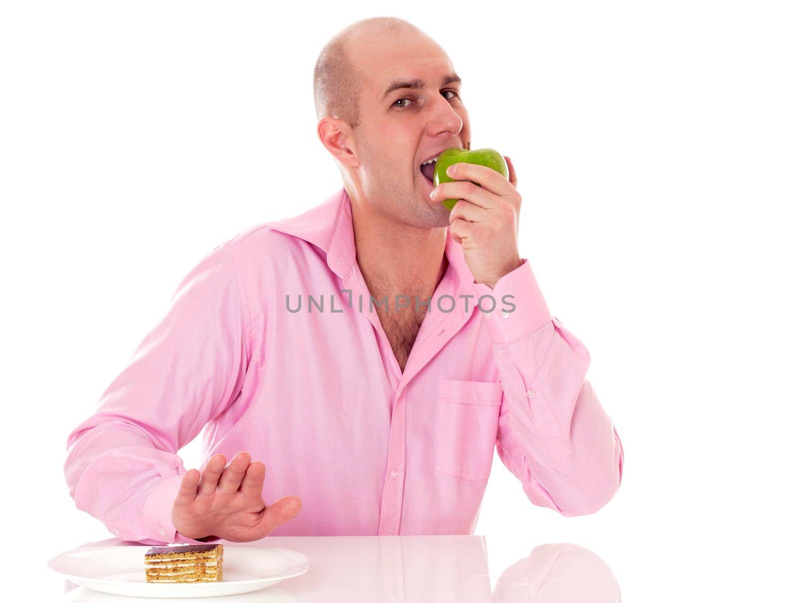 Caucasian man eating apple instead of cake, isolated on white background.