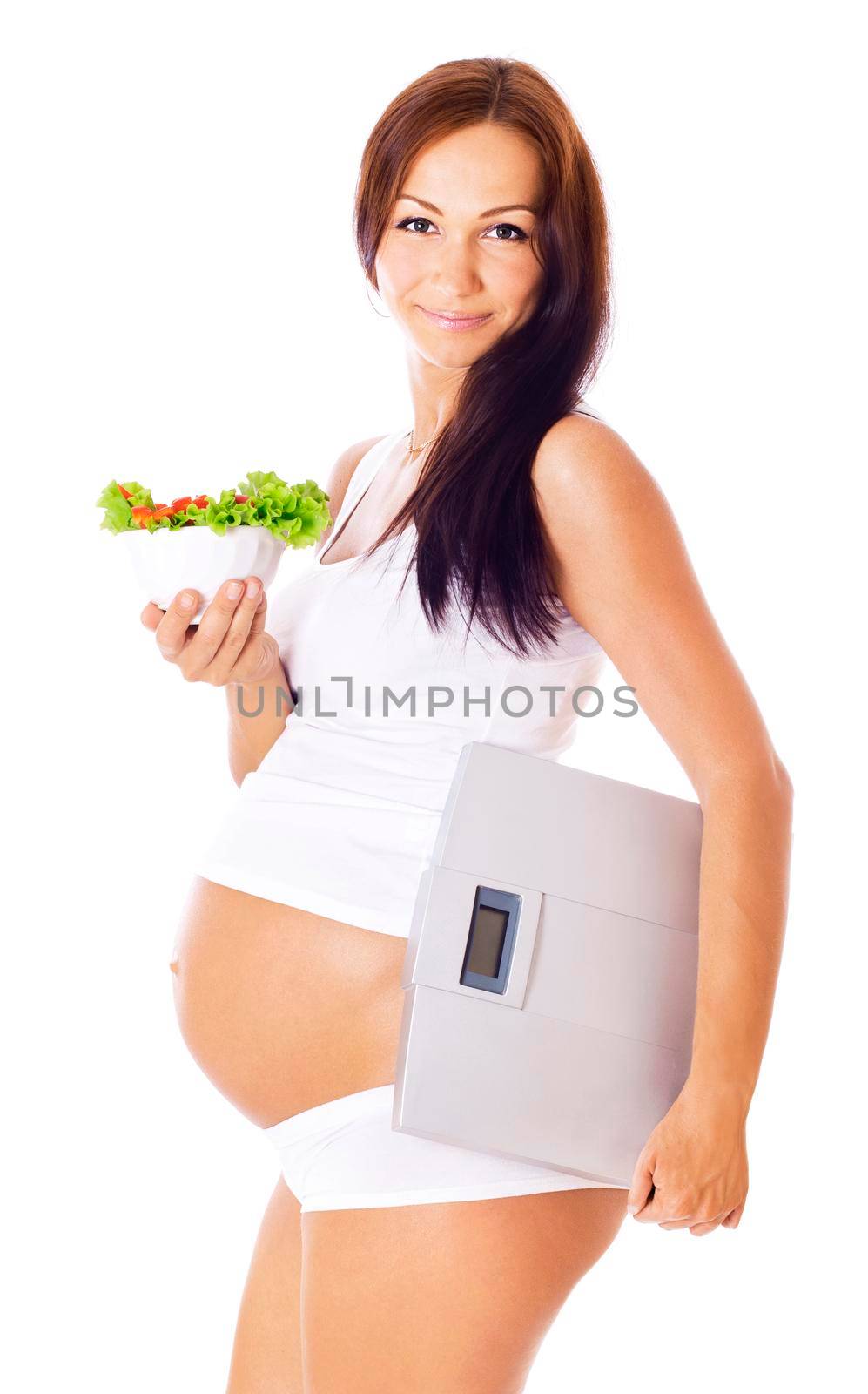 Pregnant woman holding scales in one hand to another salad, isolated on white.