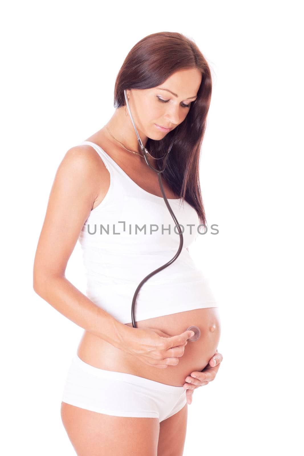 Pregnant woman listening to her baby with a stethoscope. Isolated on white.