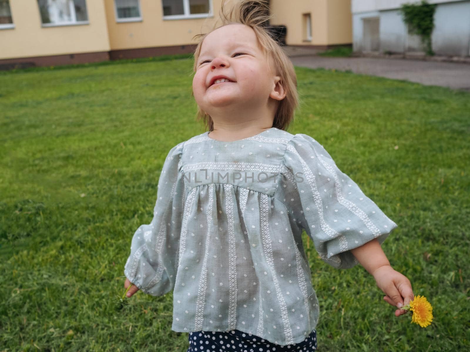 Portrait of Baby girl laughing and playing at the backyard by Varaksina