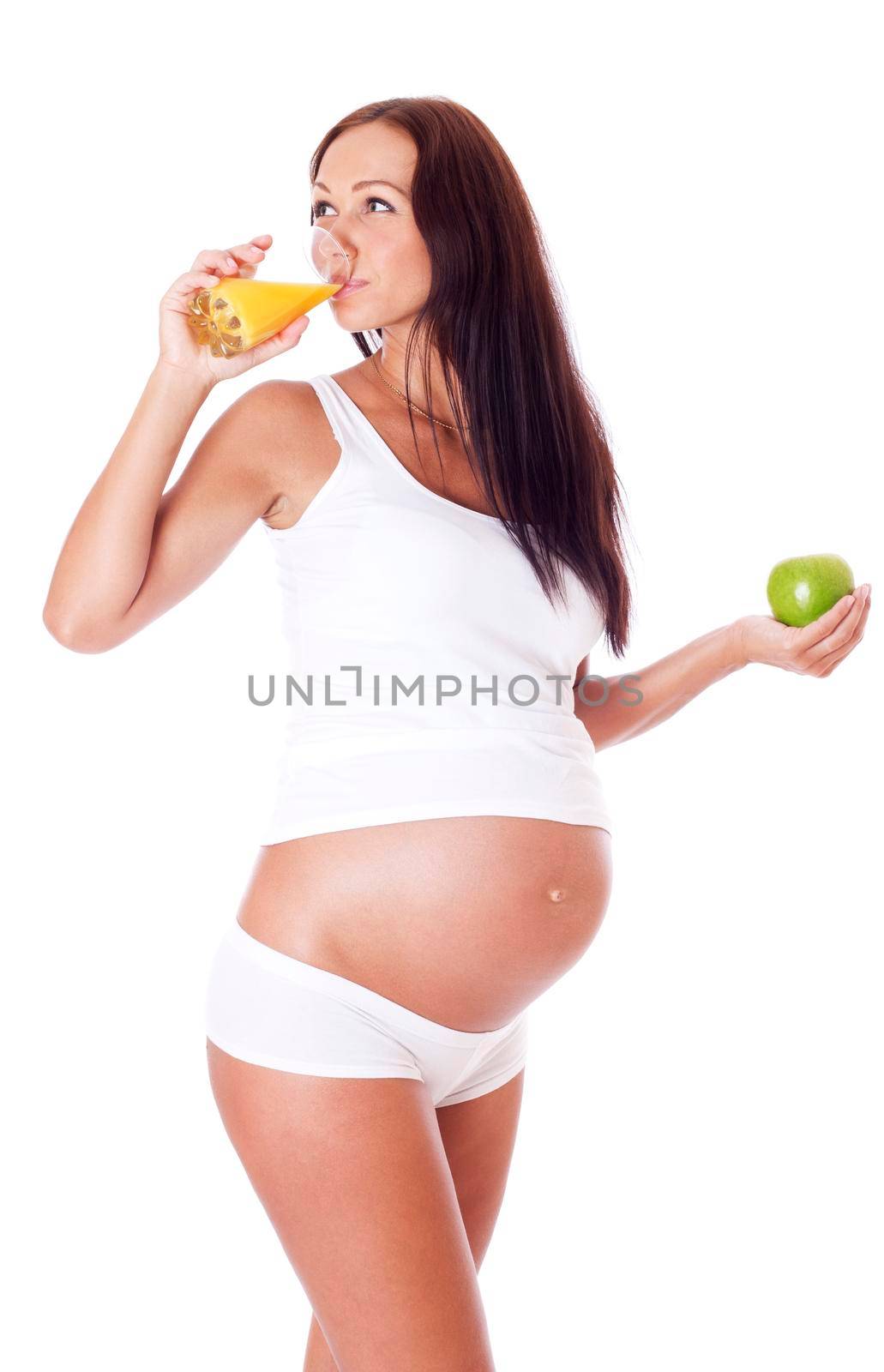 Pregnant woman holding apple and drinking juice, isolated on white