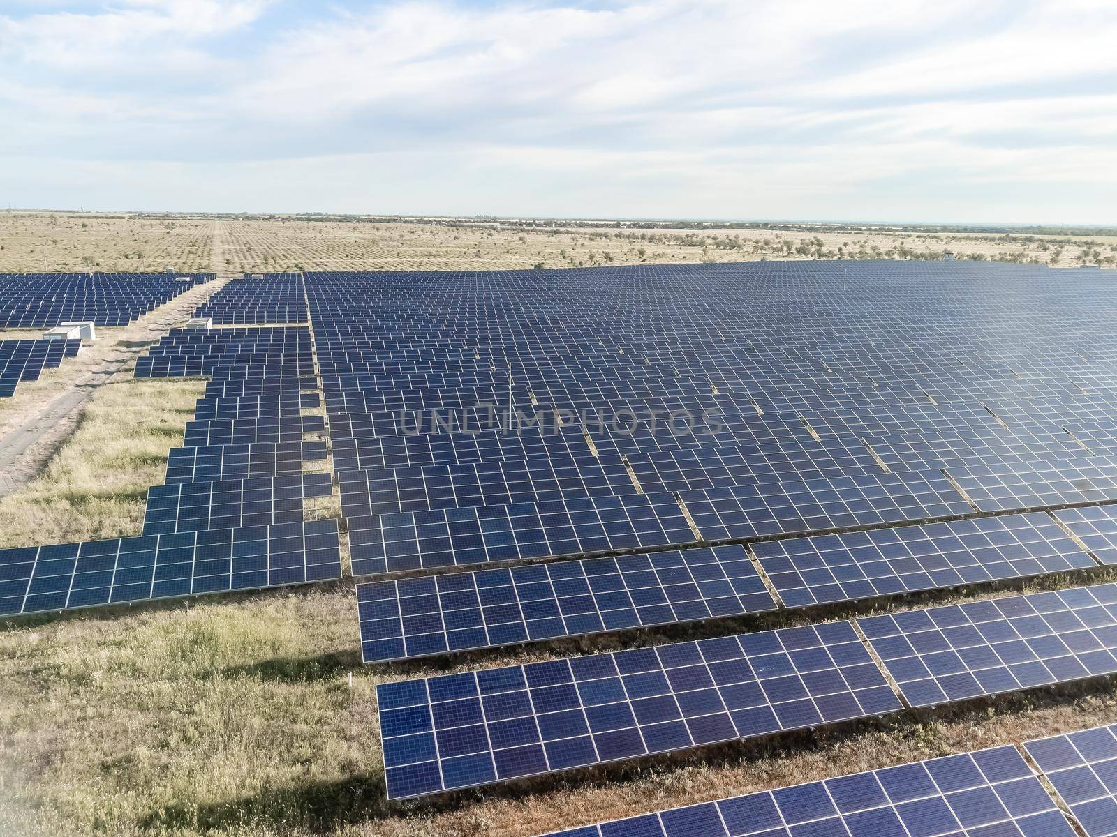 Aerial top view of a solar panels power plant. Photovoltaic solar panels at sunrise and sunset in countryside from above. Modern technology, climate care, earth saving, renewable energy concept