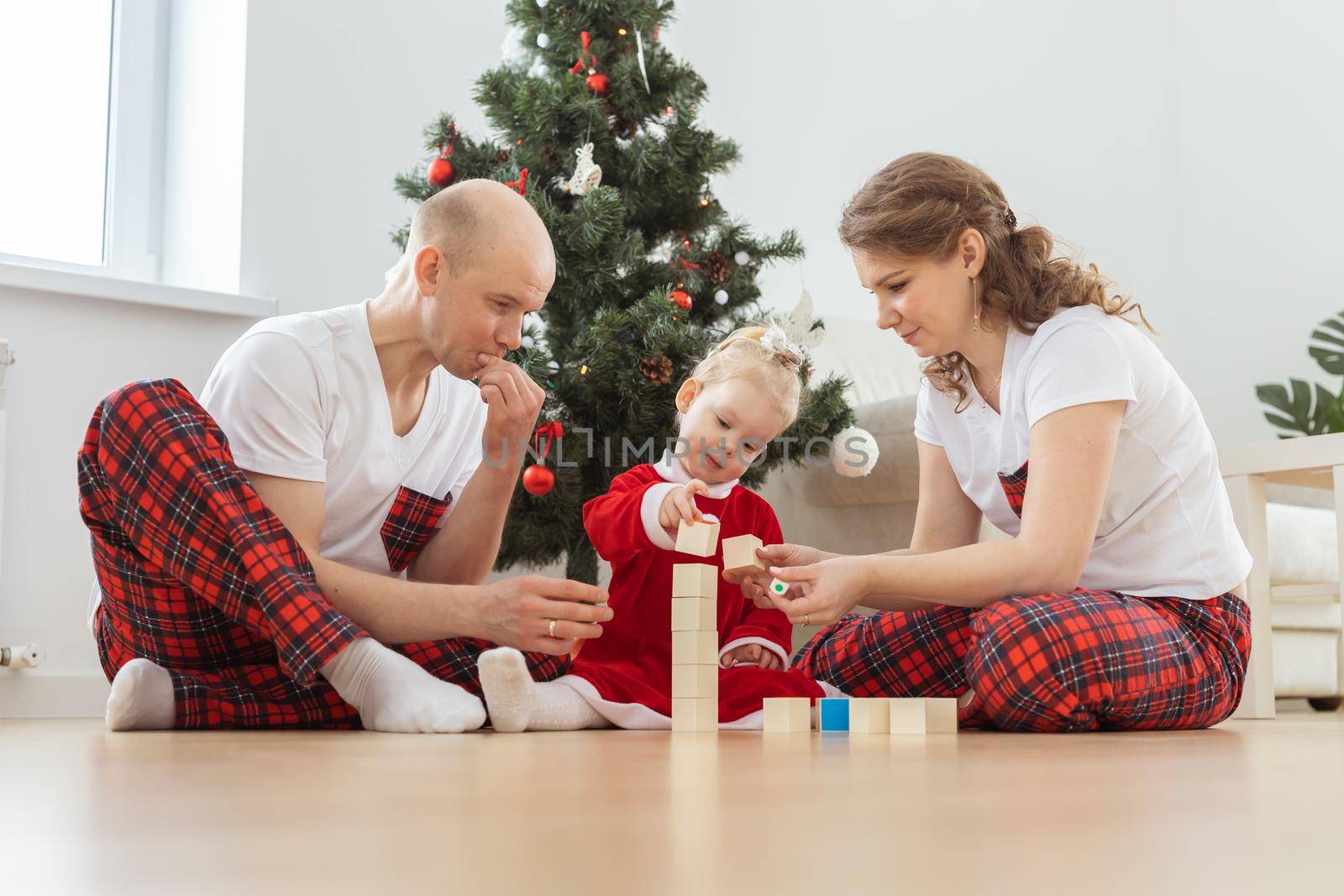 Baby child with hearing aid and cochlear implant having fun with parents in christmas room. Deaf and health