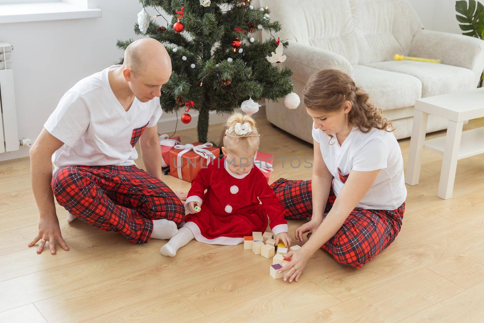 Baby child with hearing aid and cochlear implant having fun with parents in christmas room. Deaf and health