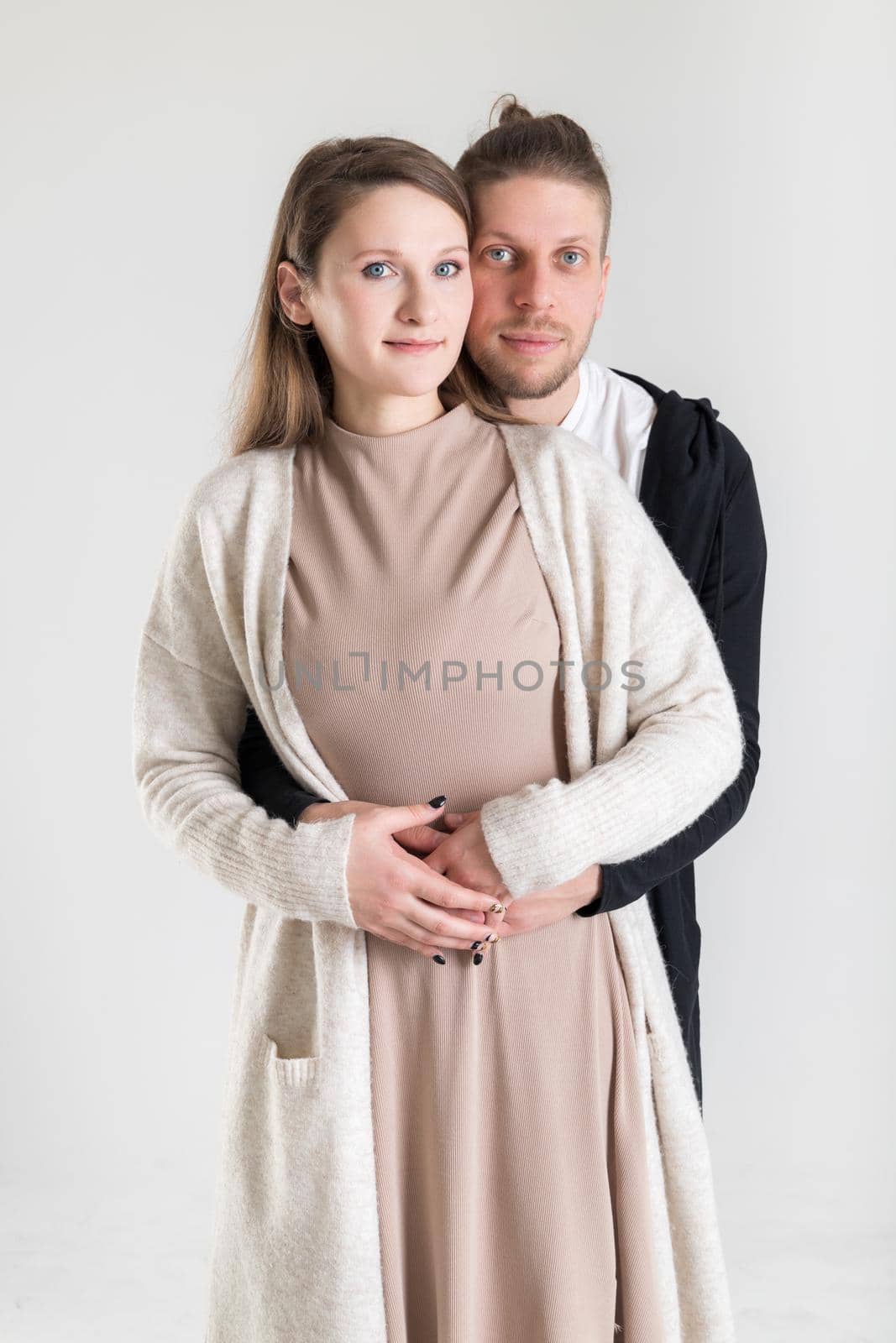 Vertical portrait of a young caucasian couple in love on a white background.