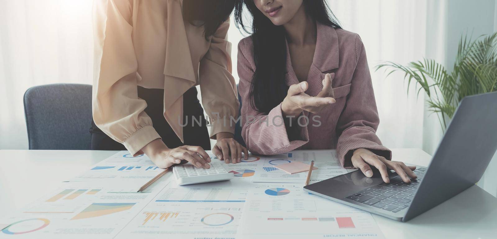 Shot of two businesswoman working together on digital tablet. Creative female executives meeting in an office using tablet pc and smiling. by wichayada