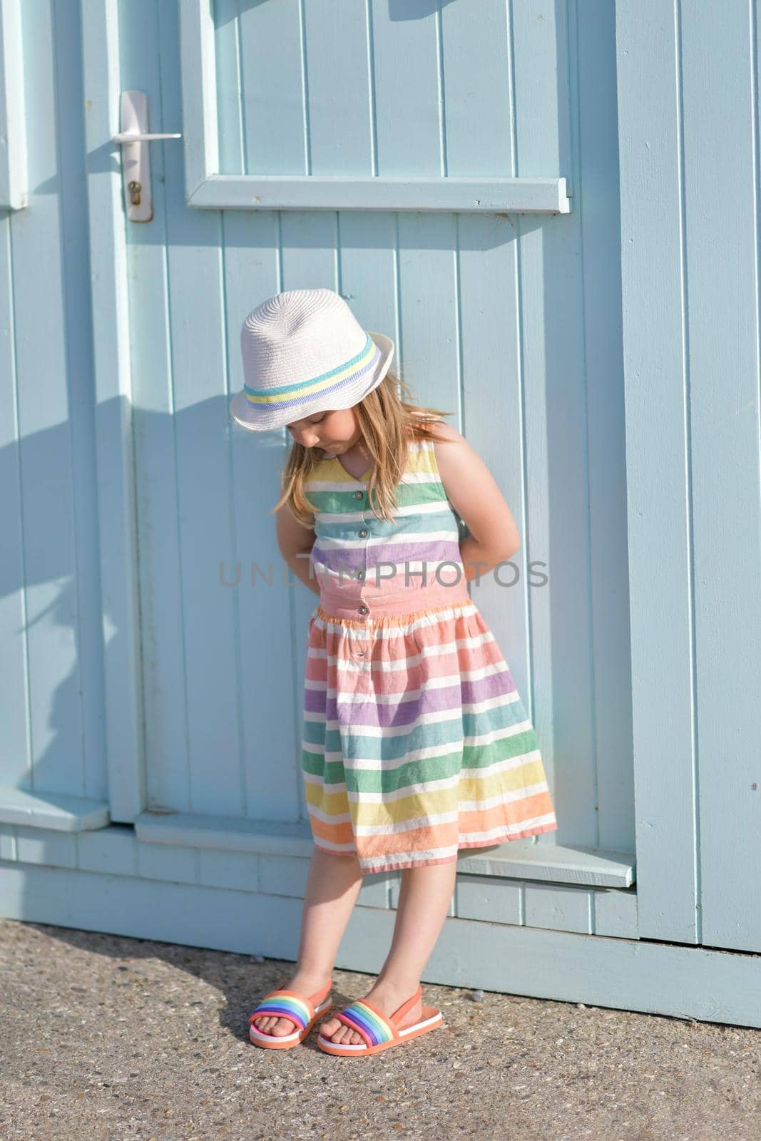 Girl in a colored dress near wooden houses on the ocean Saint aubin sur mer