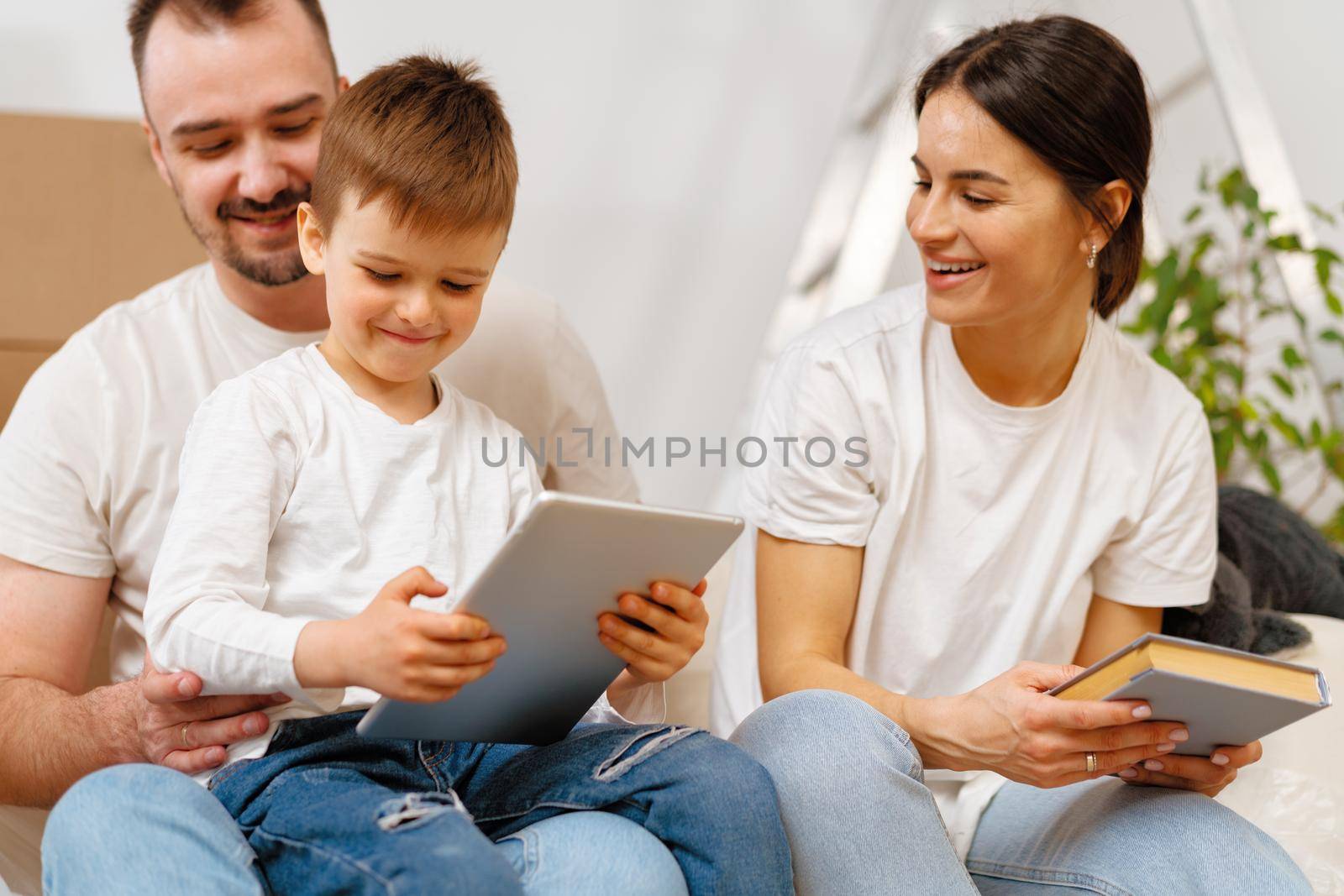 Portrait of happy family with cardboard boxes in new house at moving day by Fabrikasimf