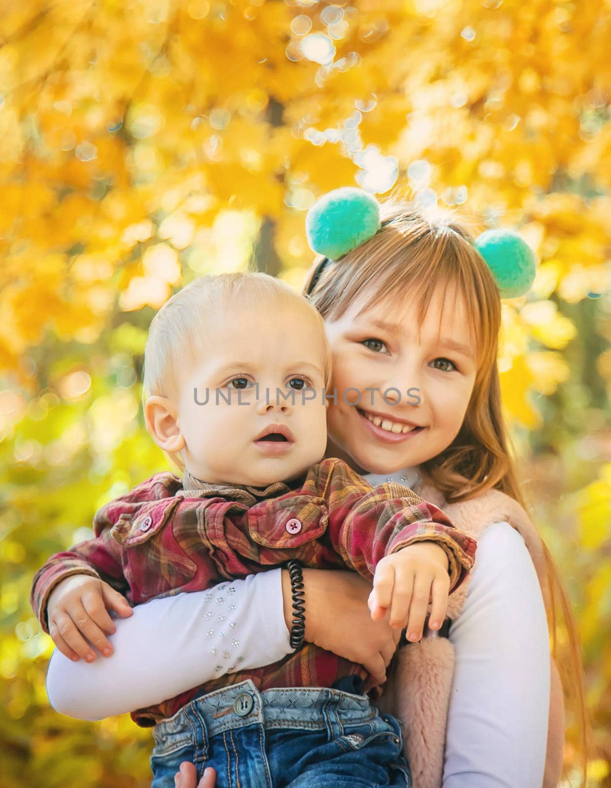 Children in the park with autumn leaves. Selective focus.