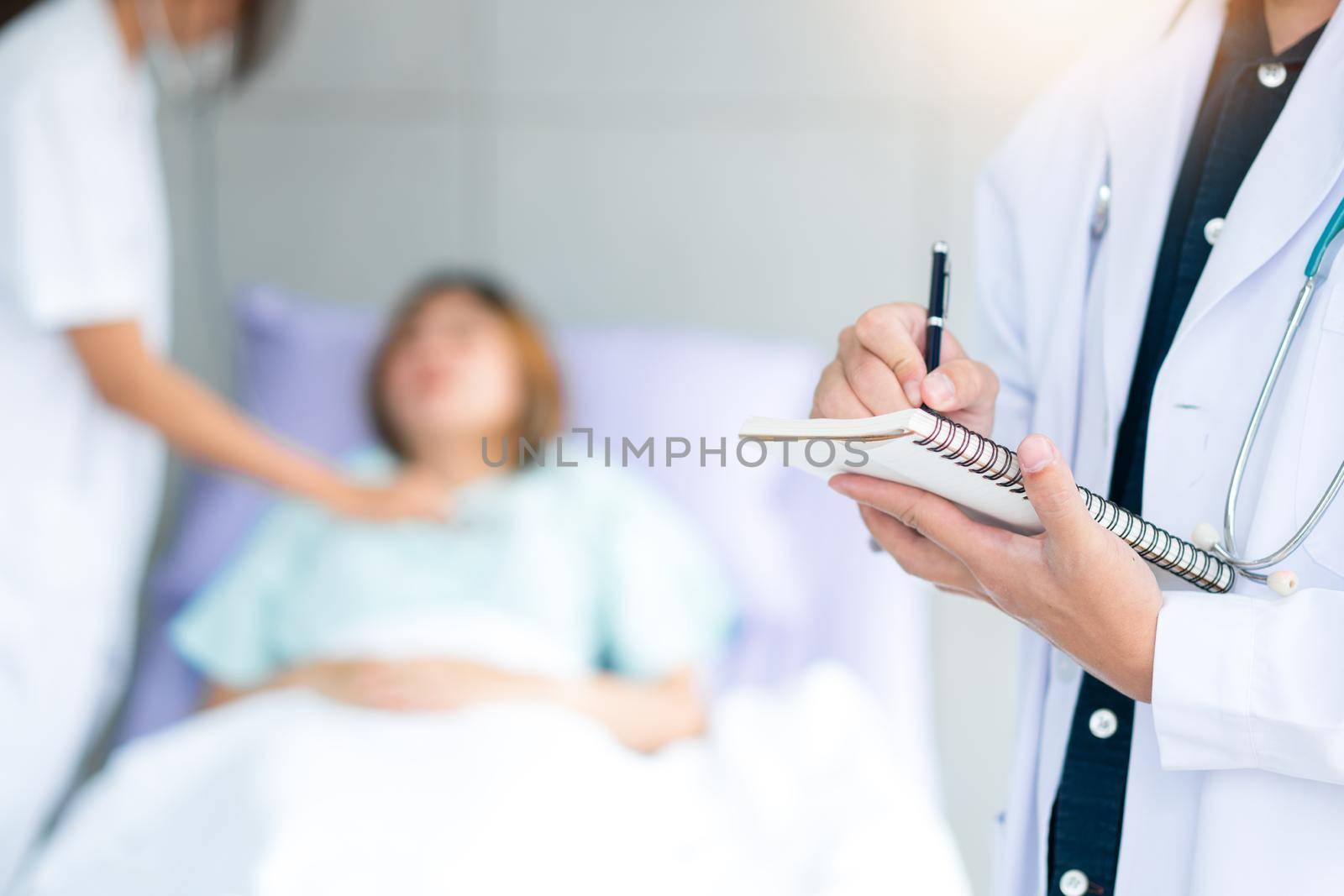 Doctor takes note in the patient room.  Health care system