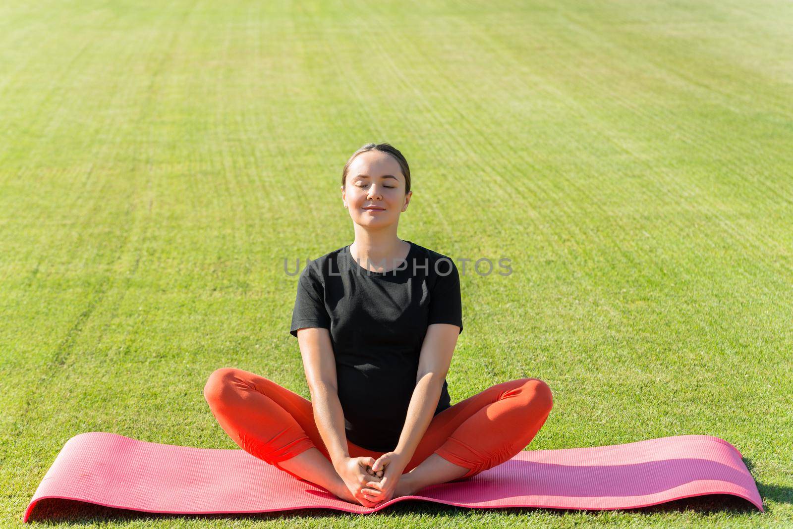 pregnant woman performs yoga asanas by maramorosz