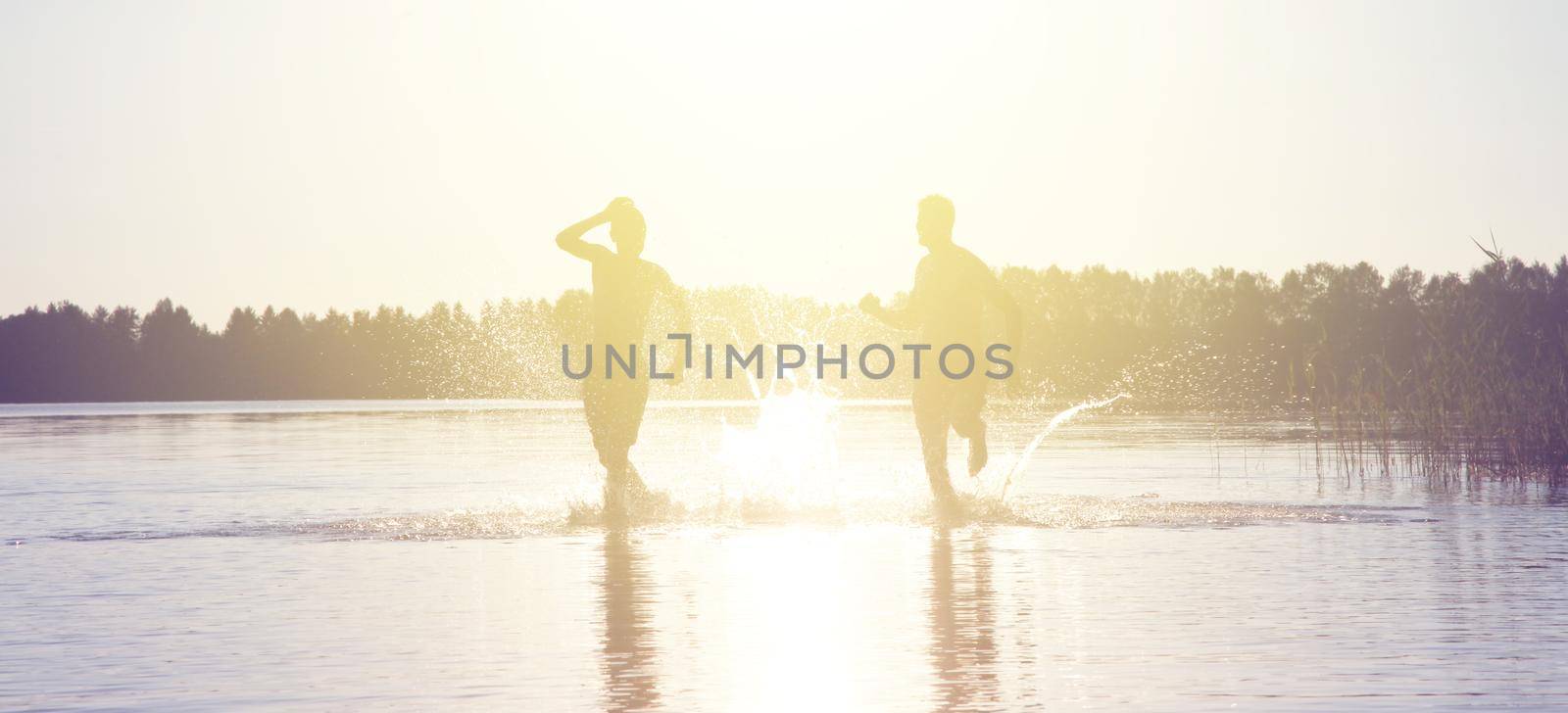 Group of young people playing games on sandy beach on a summer day.