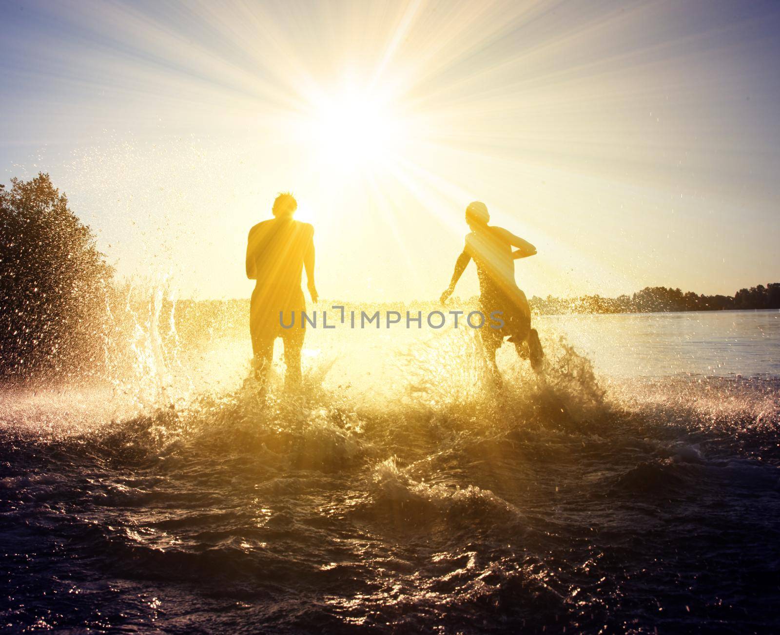 Group of young people playing games on sandy beach on a summer day.