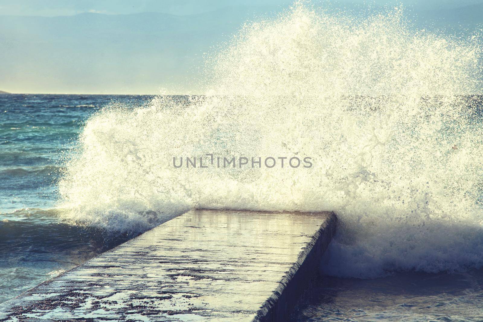 Feeling of freedom concept. Big waves beats against the pier.