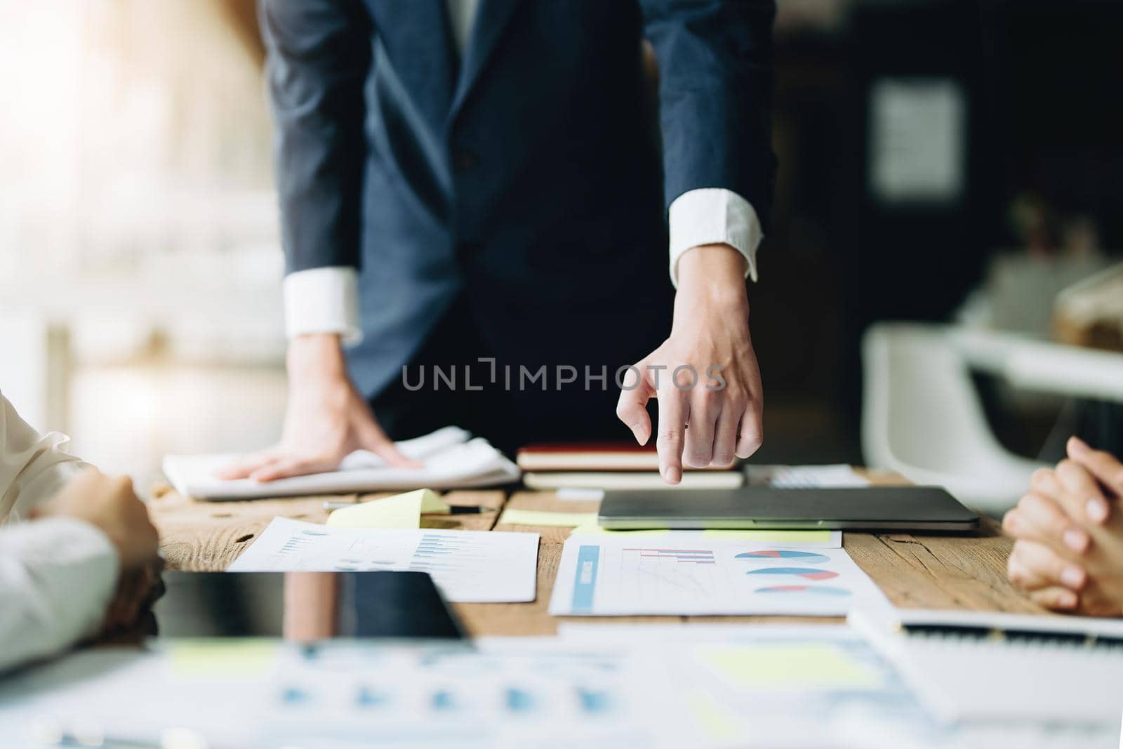Male businessman pointing to documents summarizing marketing strategy with female colleagues in meeting, teamwork, investment planning by Manastrong