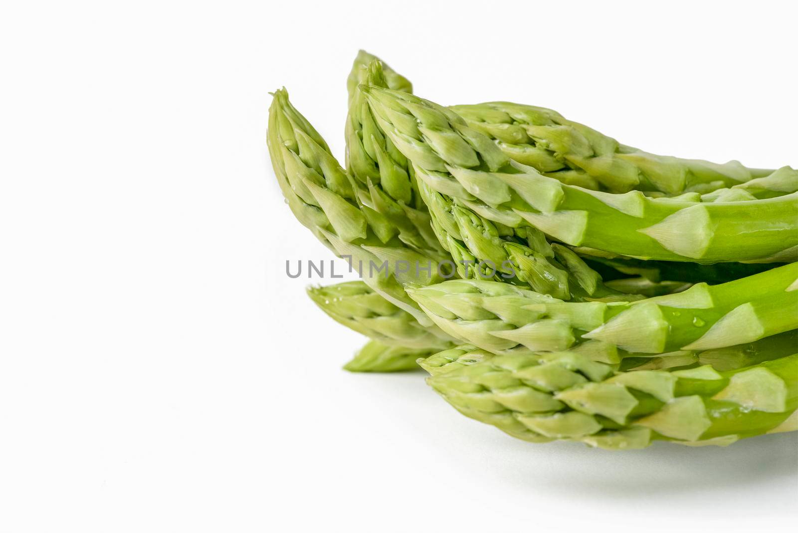 Fresh green asparagus on a white isolated background. Green asparagus isolate with shadow on white background. by SERSOL