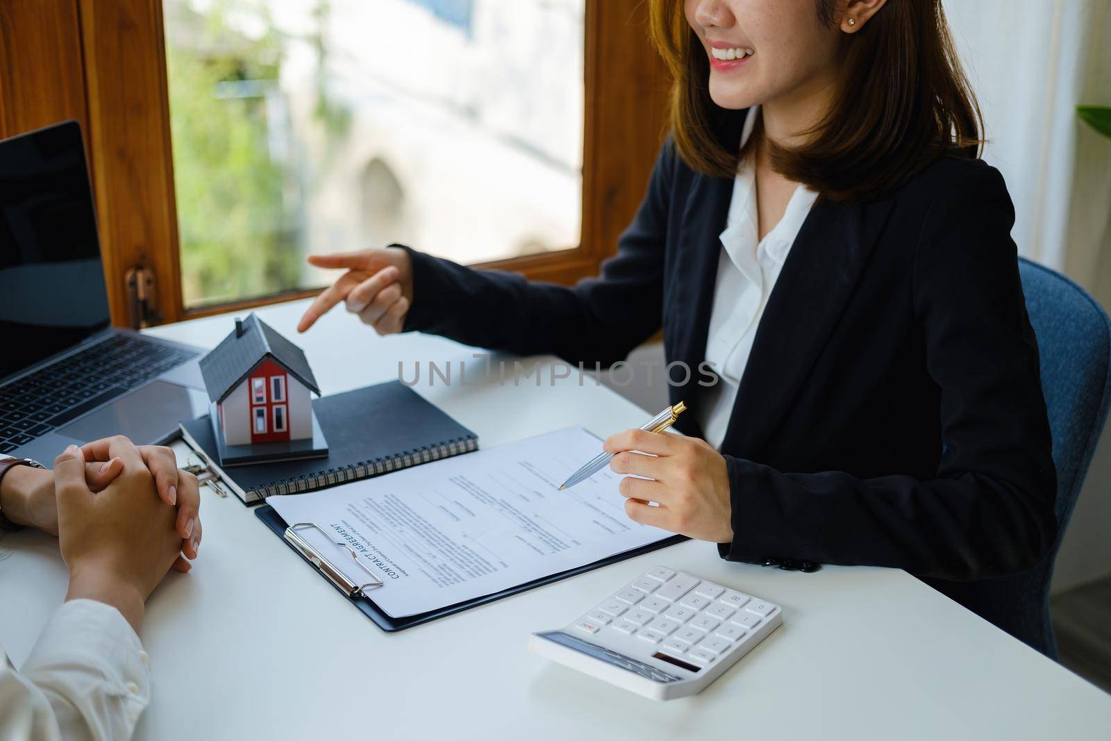 Guarantee, mortgage, agreement, contract, signed, real estate agent pointing to documents for customers to read the agreement before signing important documents.