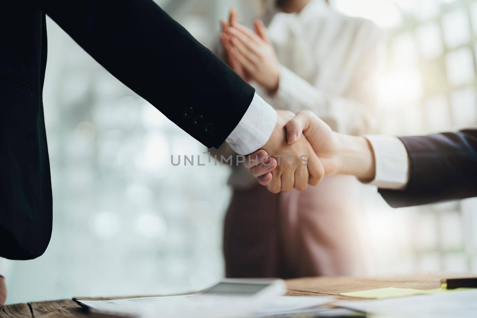 Asian entrepreneurs handshakes to congratulate the agreement between the two companies to enhance investment and financial strength. deal concept.