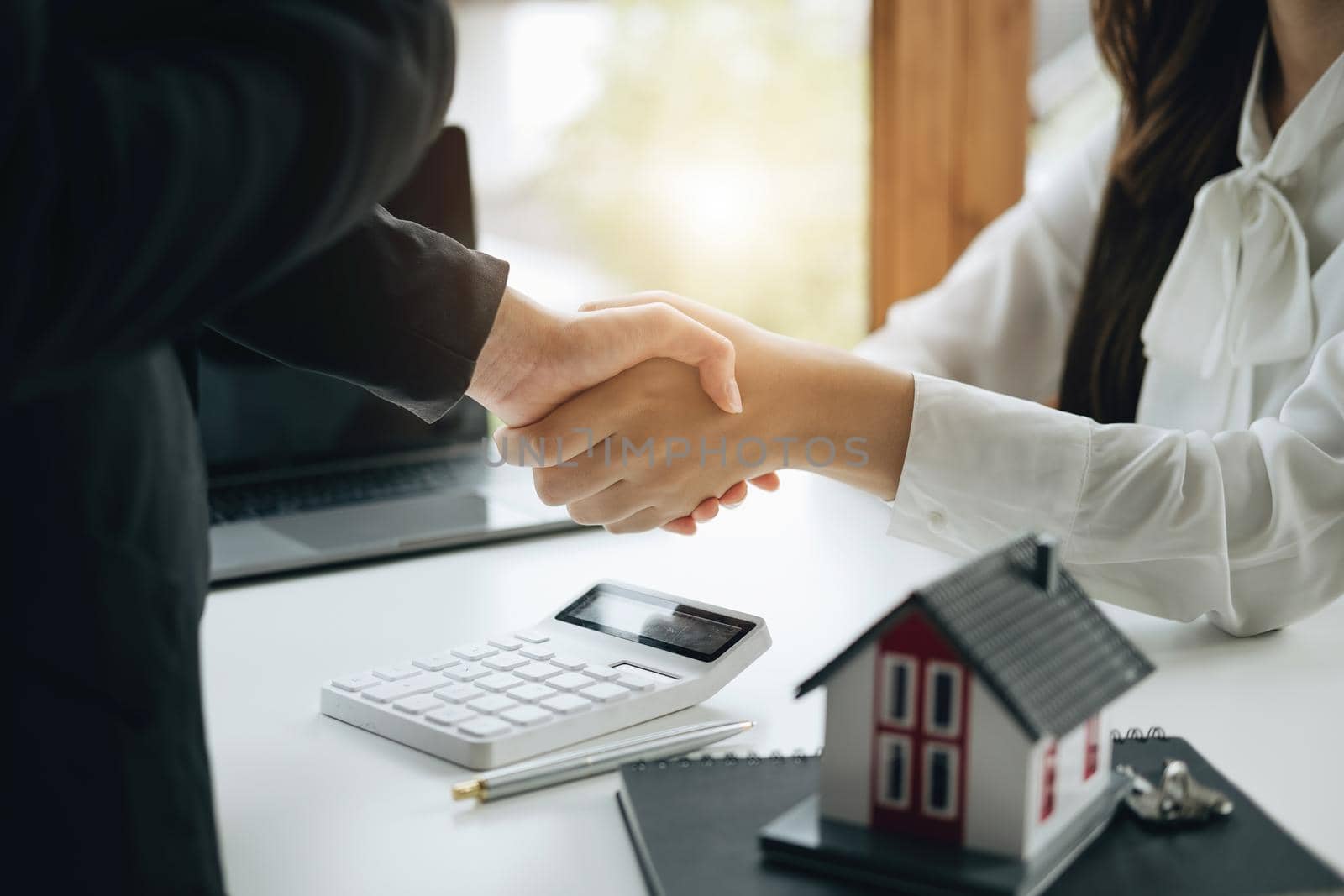 Guarantees, Mortgages, Signings, Insurance, contract, agreement concept, Real Estate Agents are shaking hands with customers to congratulate them after landing a deal by Manastrong