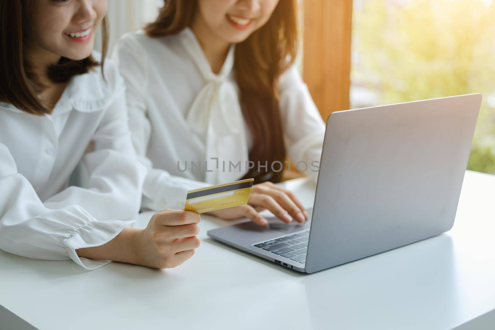 Online Shopping and Internet Payments, Beautiful Asian women are using their credit cards and computer laptop to shop online or conduct errands in the digital world.