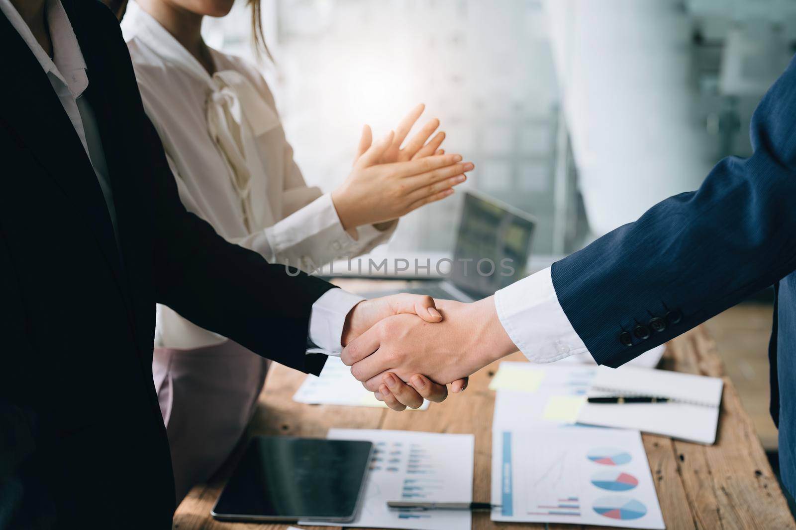 Asian entrepreneurs handshakes to congratulate the agreement between the two companies to enhance investment and financial strength. deal concept by Manastrong