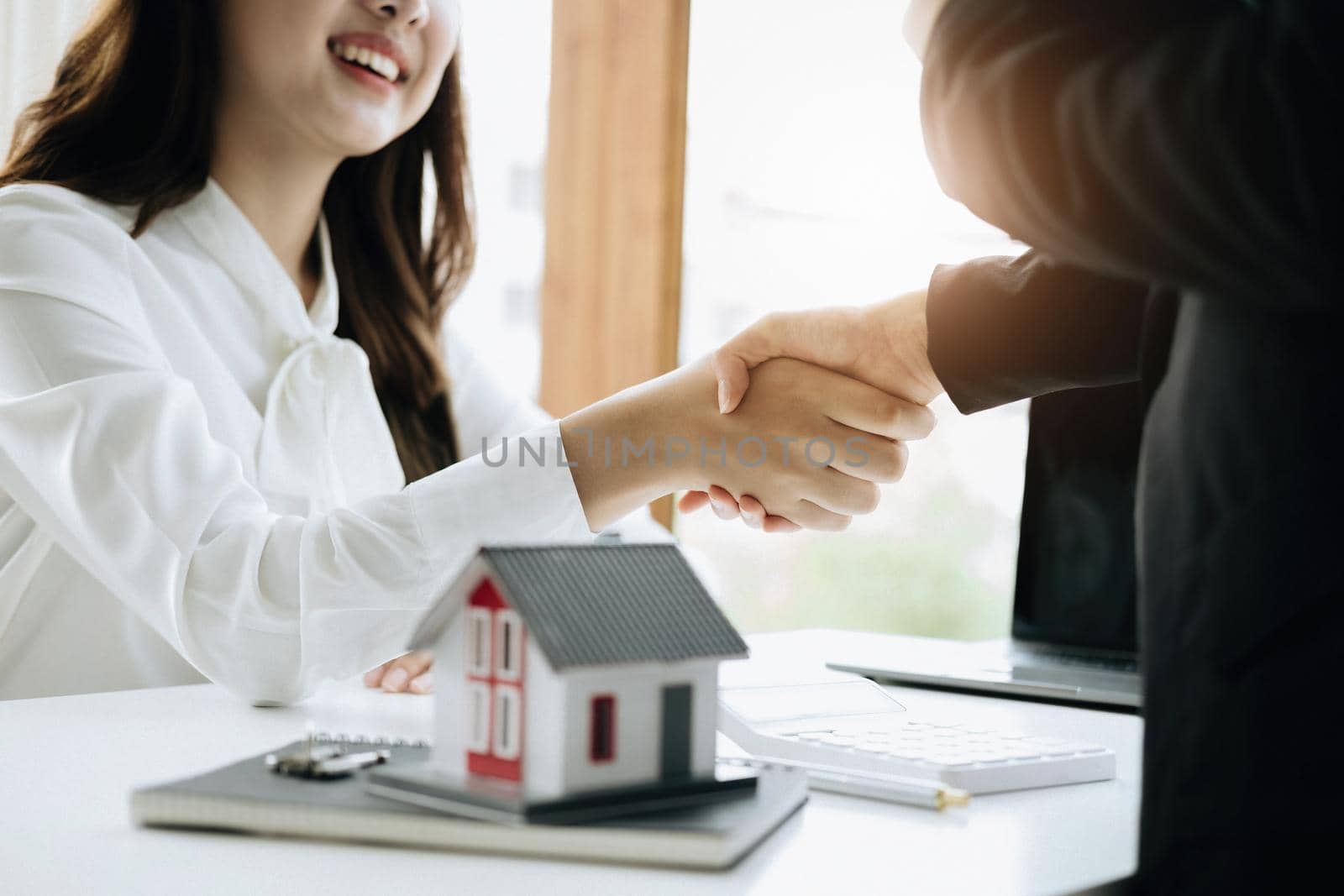 Guarantees, Mortgages, Signings, Insurance, contract, agreement concept, Real Estate Agents are shaking hands with customers to congratulate them after landing a deal by Manastrong