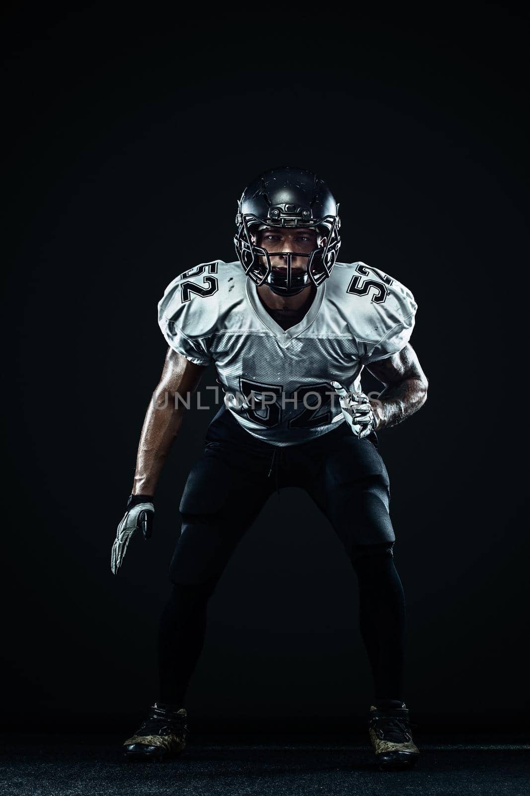 American football sportsman player in helmet on black background. Sport and motivation. Team sports. by MikeOrlov