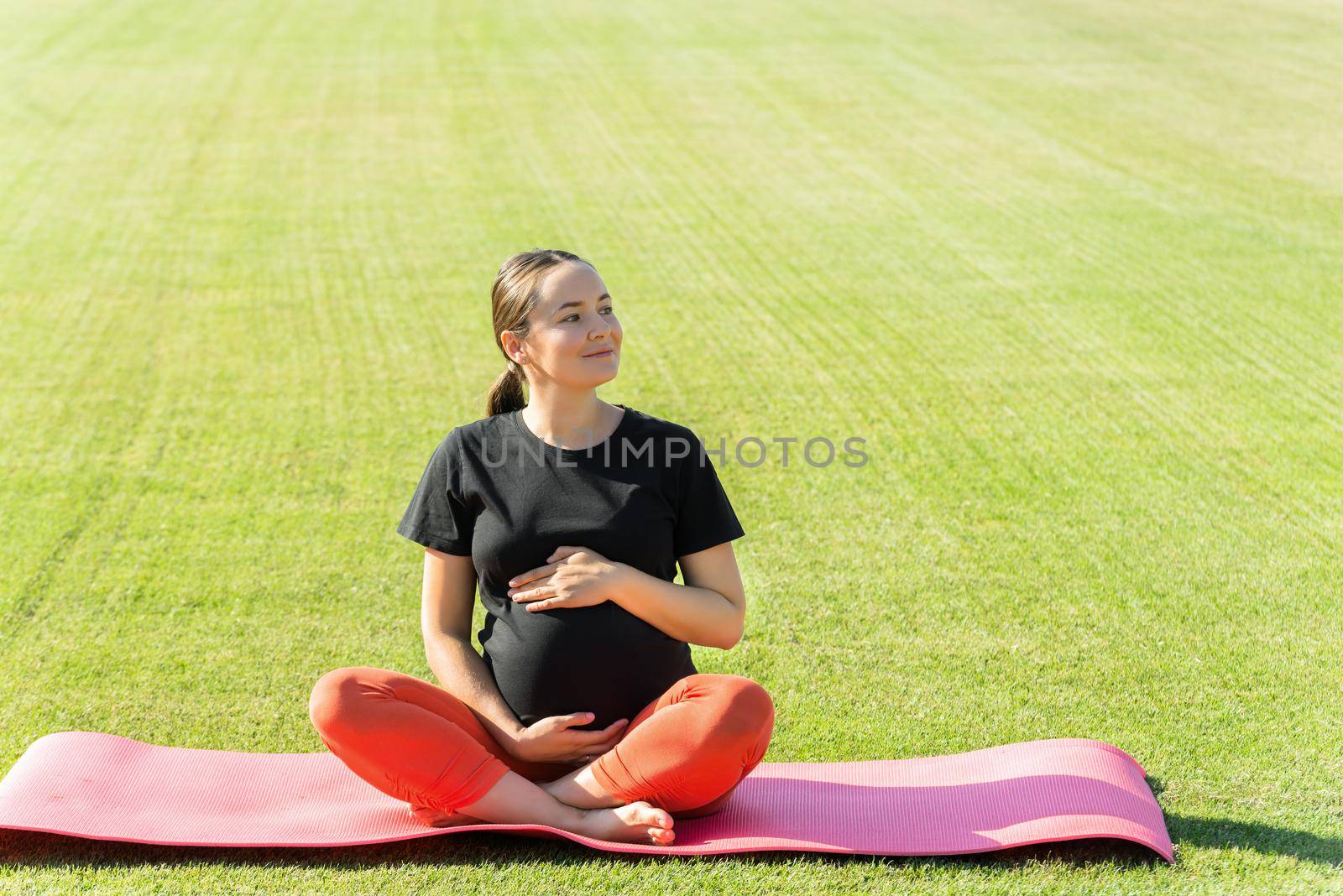 pregnant woman performs yoga asanas by maramorosz