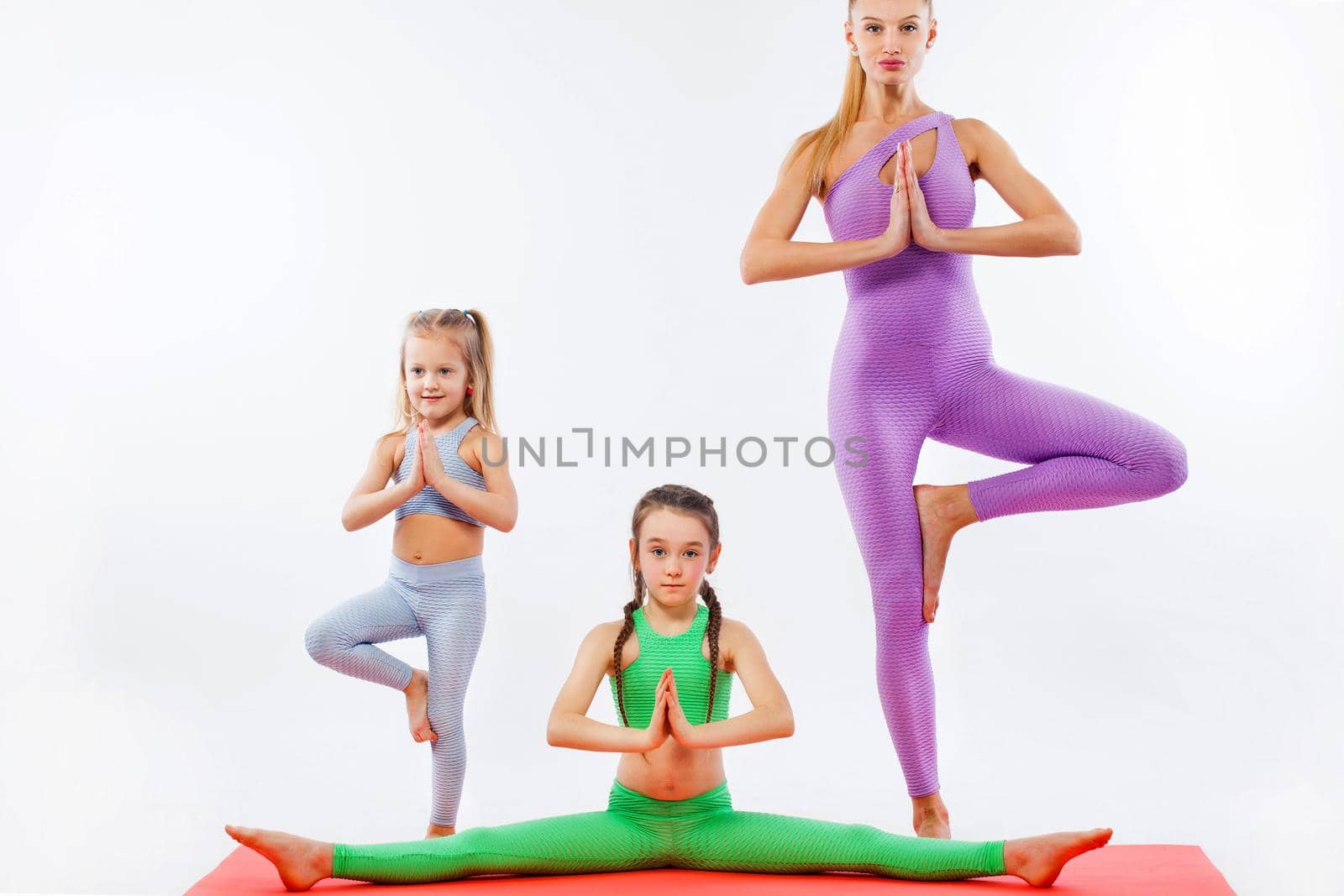 Girls and Instructor or mother doing gymnastic exercises in fitness class
