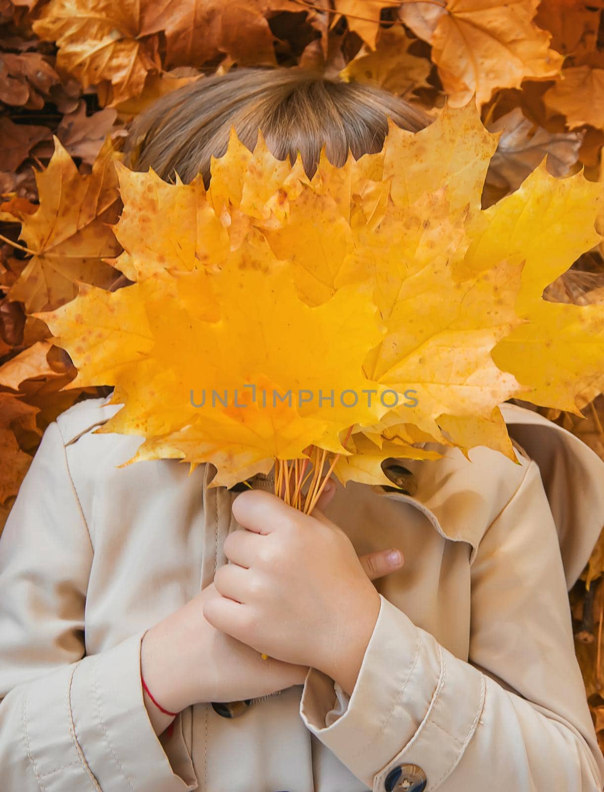 Children in the park with autumn leaves. Selective focus. by yanadjana