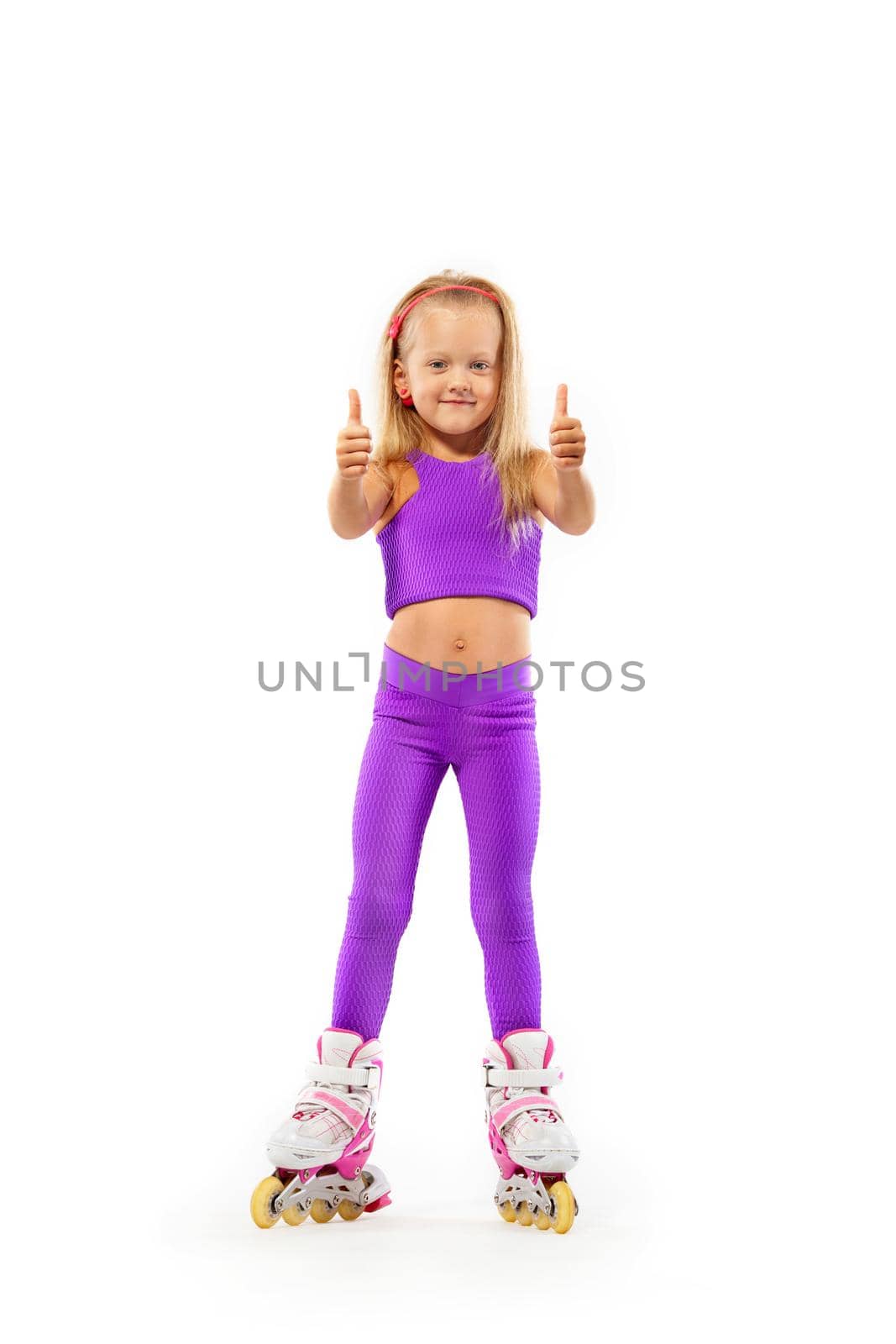 Girl, kid posing in studio wearing inline rollerskates by MikeOrlov