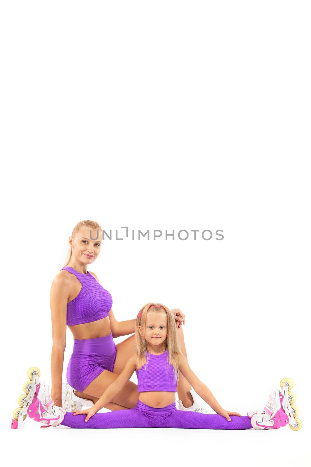 Family, mother and daughter, posing in studio wearing inline rollerskates by MikeOrlov