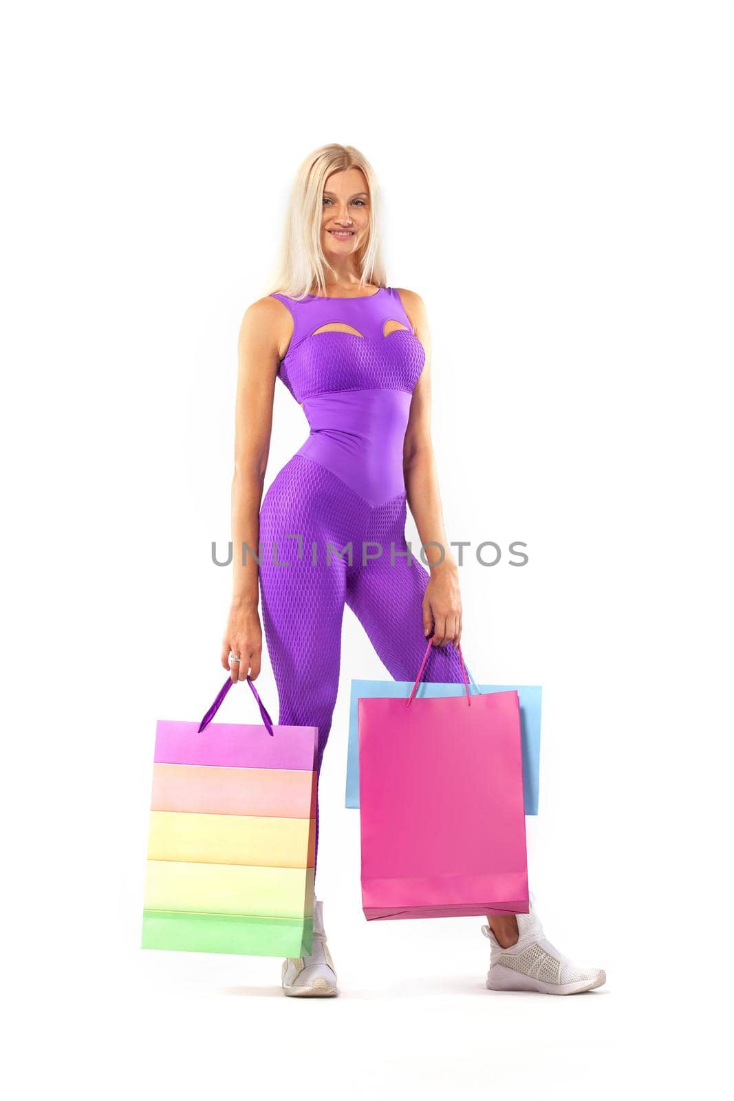 Black friday sale concept for fitness shops. Shopping woman athlete holding color bag isolated on yellow background in holiday by MikeOrlov