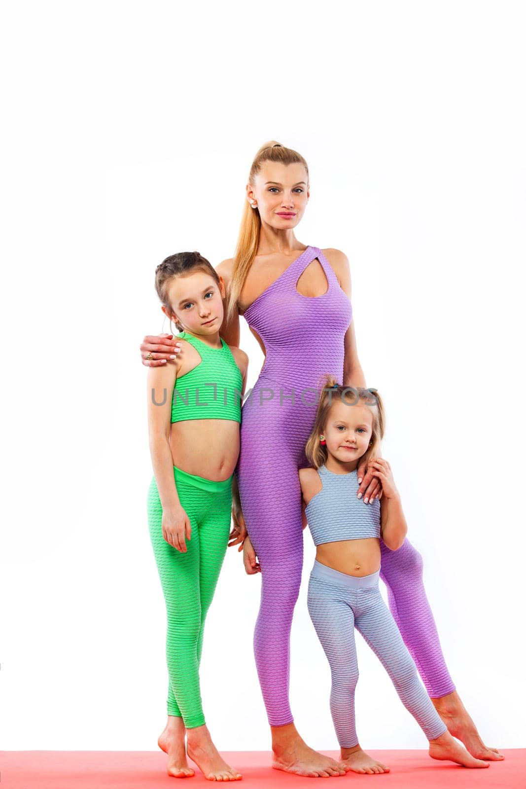 Fitness family. Hatha yoga. Young mother Instructor and daughters exercise gymnastic together. Isolated on white background. Family look. by MikeOrlov