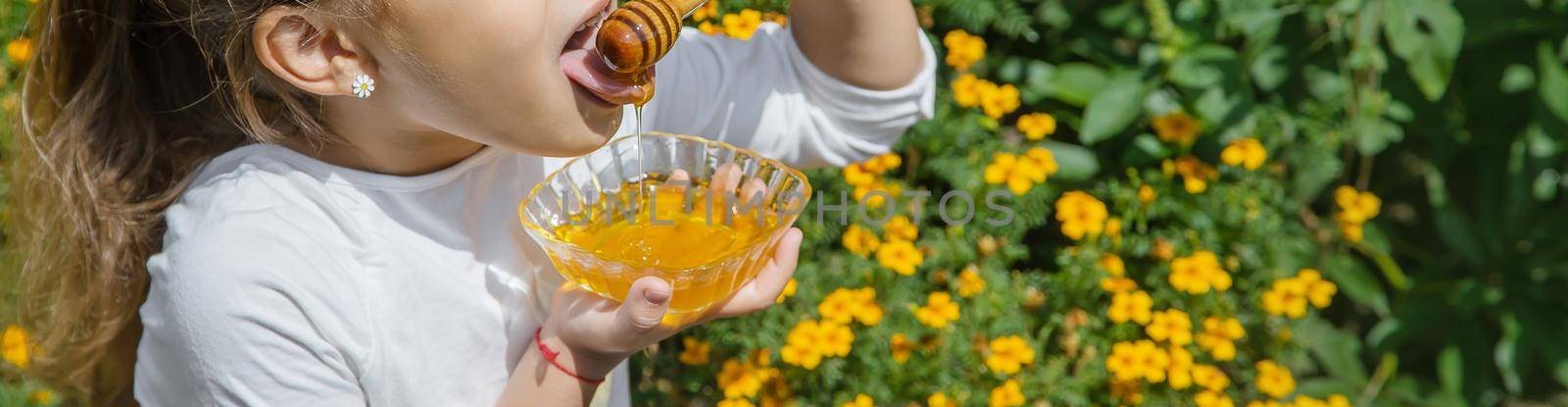 Child a plate of honey in the hands. Selective focus. by yanadjana