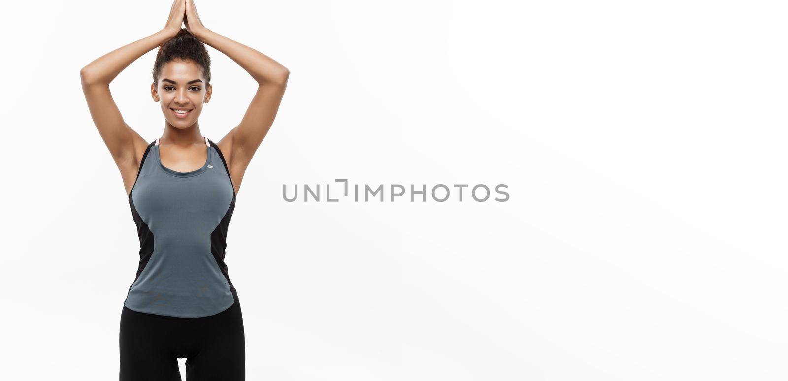 Healthy and Fitness concept - Beautiful American African lady in fitness clothing doing yoga and meditation. Isolated on white background