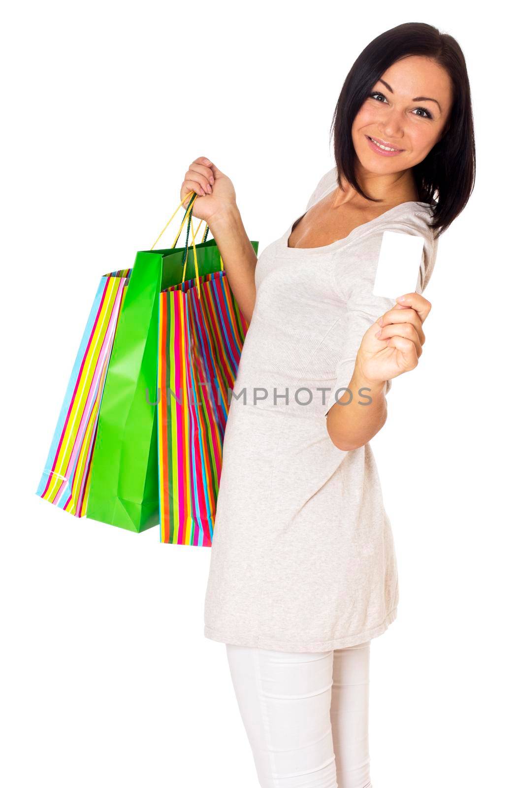 Beautiful woman holding credit card and bags. Isolated on white.