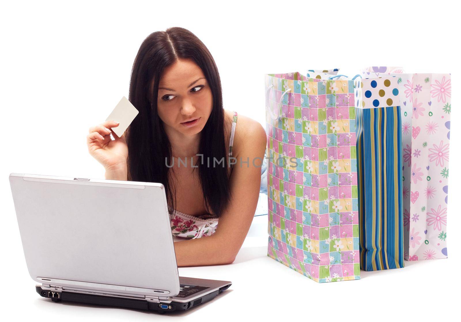 Beautiful woman contemplates her online purchase. Isolated on white.