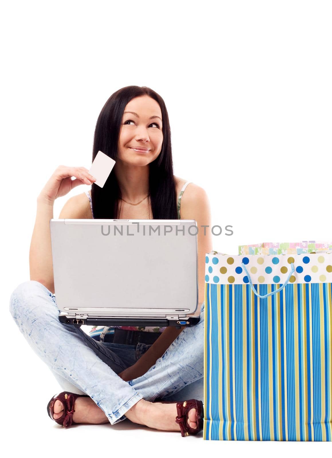 Beautiful woman contemplates her online purchase. Isolated on white.