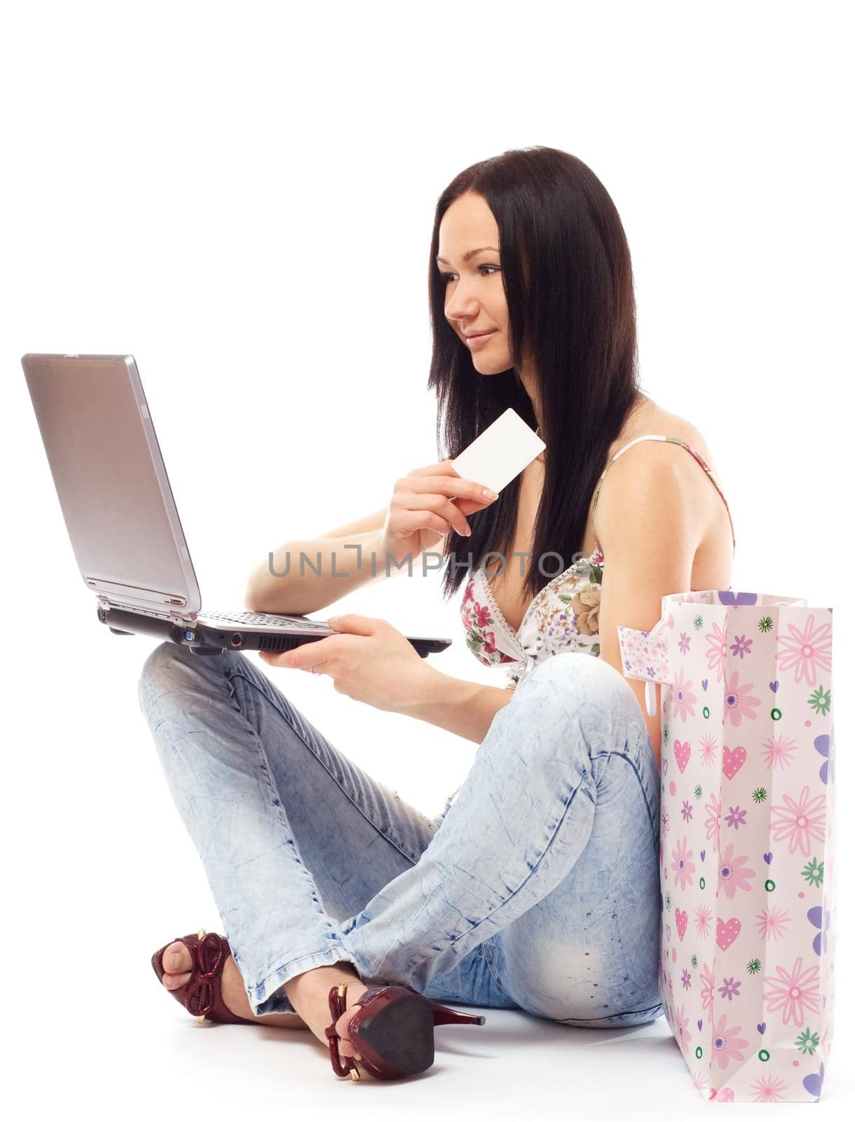 Beautiful woman contemplates her online purchase. Isolated on white.