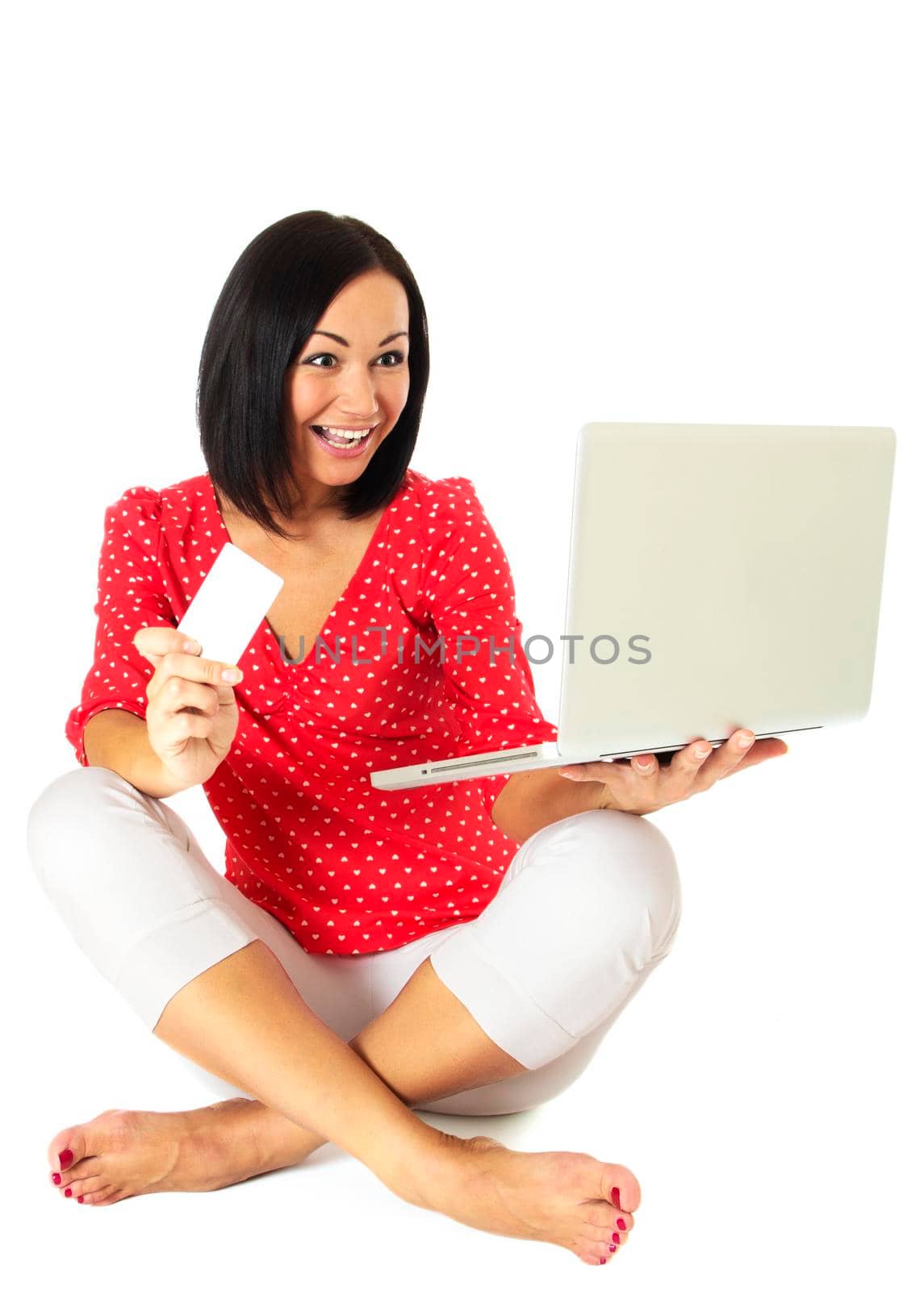 Beautiful woman contemplates her online purchase. Isolated on white.