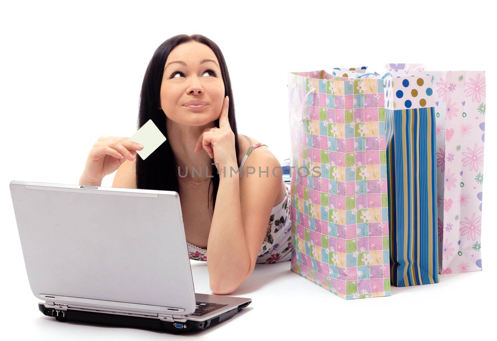 Beautiful woman contemplates her online purchase. Isolated on white.