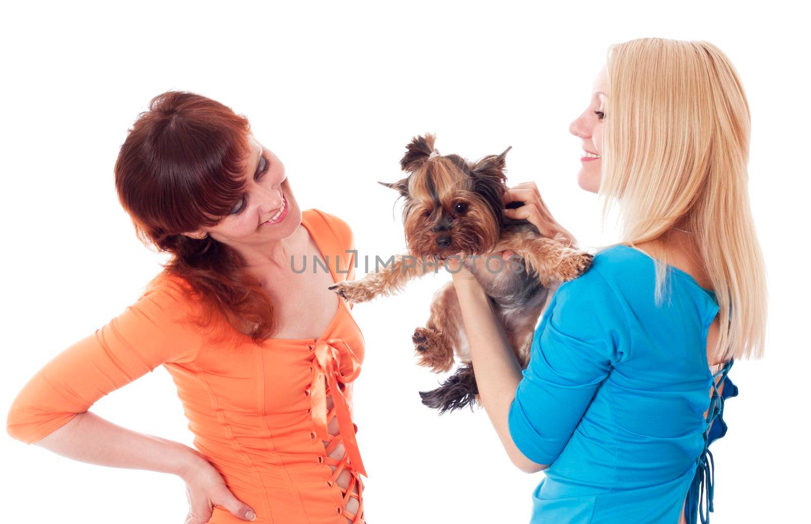 Two women holding their pet Yorkshire Terrier.