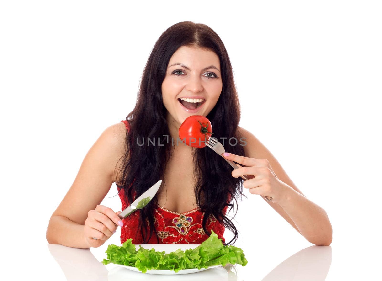 Happy young woman eating salad. by Jyliana