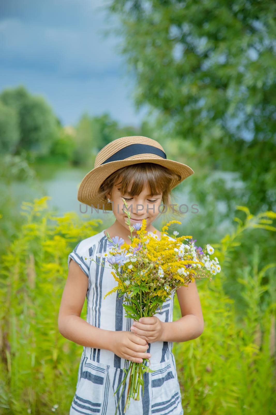 girl holding wildflowers in the hands of a child. Selective focus.