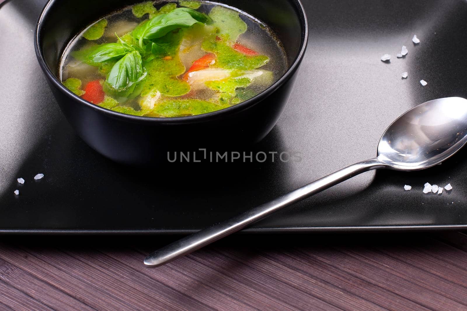 Tuscan vegetable soup with basil pesto in black plate