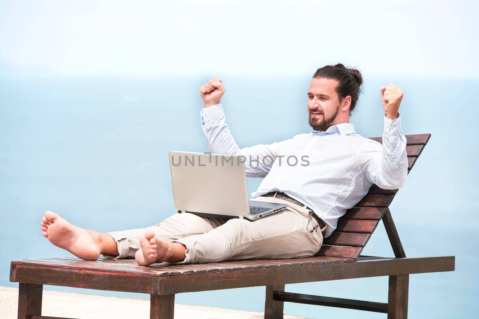 Businessman freelance on beach with laptop by Jyliana