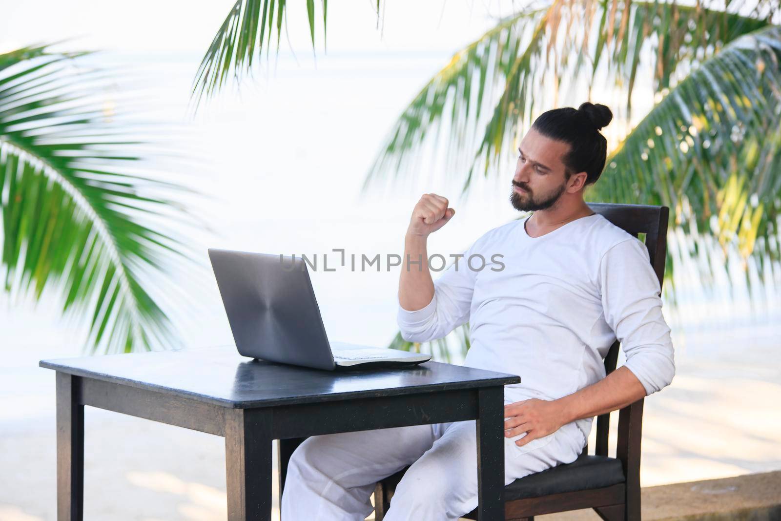 telecommuting, businessman relaxing on the beach with laptop and palm, freelancer workplace, dream job. Showing win